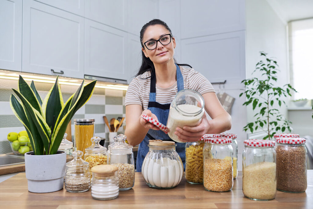 A woman is showing the jarred packaged goods.