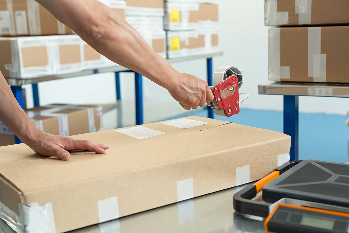 Ein Mann verpackt in der Fabrik eine Bestellung